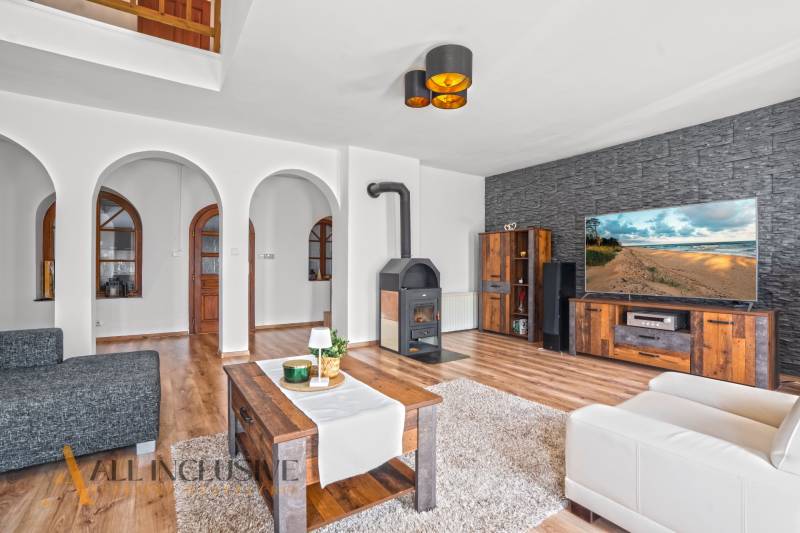 REZERVOVANÉ ZREKONŠTR. 6 IZBOVÝ RODINNÝ DOM, KOŠÚTY - Obývacia izba v rodinnom dome s krbom, oblúkovými dverami a podlahou s dreveným dekorom.