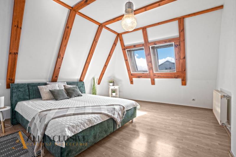 REZERVOVANÉ ZREKONŠTR. 6 IZBOVÝ RODINNÝ DOM, KOŠÚTY - Podkrovná spálňa v rodinnom dome s posteľou a podlahou s dreveným dekorom.