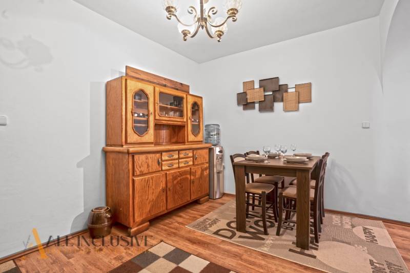 REZERVOVANÉ ZREKONŠTR. 6 IZBOVÝ RODINNÝ DOM, KOŠÚTY - Jedálenský kút v rodinnom dome s dreveným príborníkom a podlahou s dreveným dekorom.