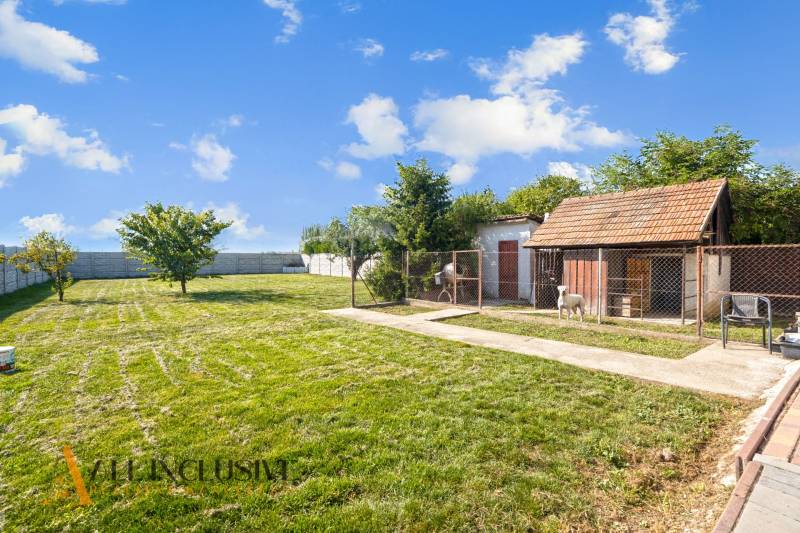 REZERVOVANÉ ZREKONŠTR. 6 IZBOVÝ RODINNÝ DOM, KOŠÚTY - Záhrada rodinného domu v Košútoch s dreveným domčekom a udržiavaným trávnikom.