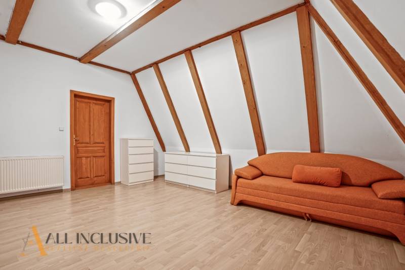 REZERVOVANÉ ZREKONŠTR. 6 IZBOVÝ RODINNÝ DOM, KOŠÚTY - Izba v rodinnom dome s oranžovou sedačkou, bielymi komodami a podlahou s dreveným dekorom.