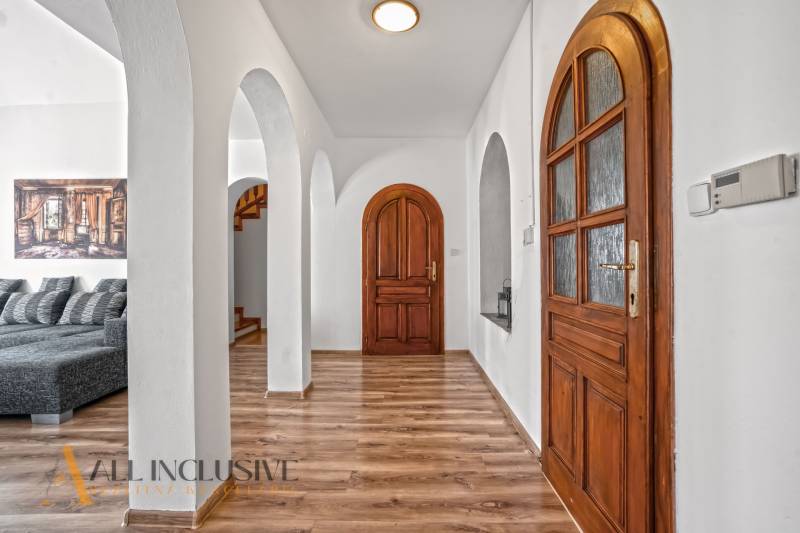 REZERVOVANÉ ZREKONŠTR. 6 IZBOVÝ RODINNÝ DOM, KOŠÚTY - Interiérová chodba v Rodinnom dome s oblúkmi, podlaha s dreveným dekorom.