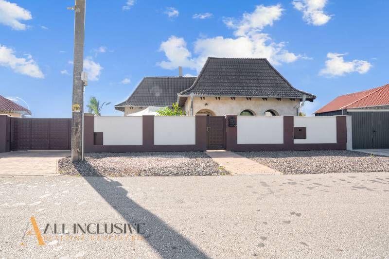 REZERVOVANÉ ZREKONŠTR. 6 IZBOVÝ RODINNÝ DOM, KOŠÚTY - Rodinný dom v Košútoch s veľkou bránou a kamenným dvorom, modrá obloha.