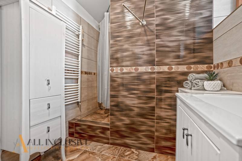 REZERVOVANÉ ZREKONŠTR. 6 IZBOVÝ RODINNÝ DOM, KOŠÚTY - Kúpeľňa s úložnou skriňou, otvoreným sprchovým kútom a dekoráciami v Rodinnom dome.