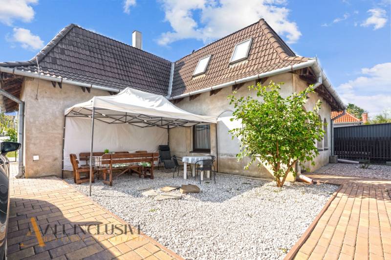 REZERVOVANÉ ZREKONŠTR. 6 IZBOVÝ RODINNÝ DOM, KOŠÚTY - Rodinný dom v Košútoch s terasou, altánkom a kamienkovým dvorom pod modrou oblohou.