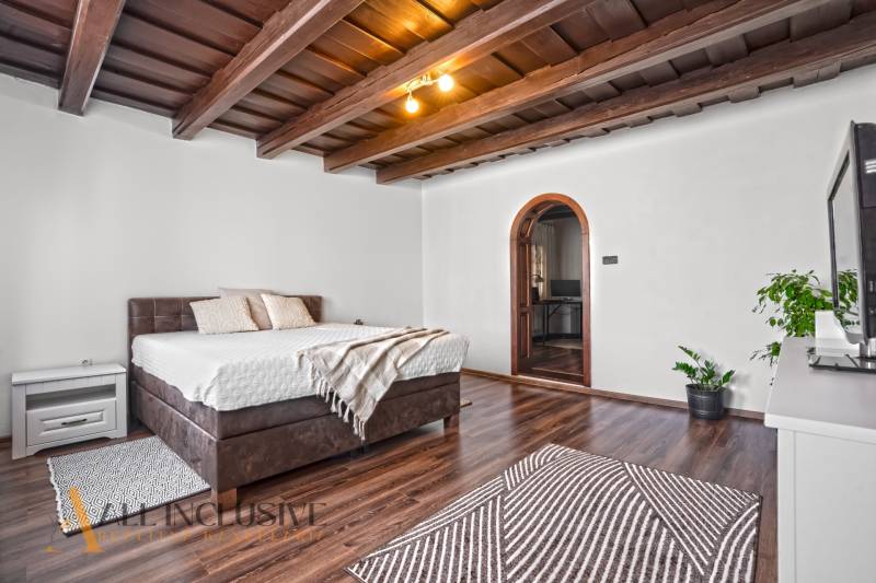 REZERVOVANÉ ZREKONŠTR. 6 IZBOVÝ RODINNÝ DOM, KOŠÚTY - Spálňa v rodinnom dome s oblúkovými dverami, posteľou a podlahou s dreveným dekorom.