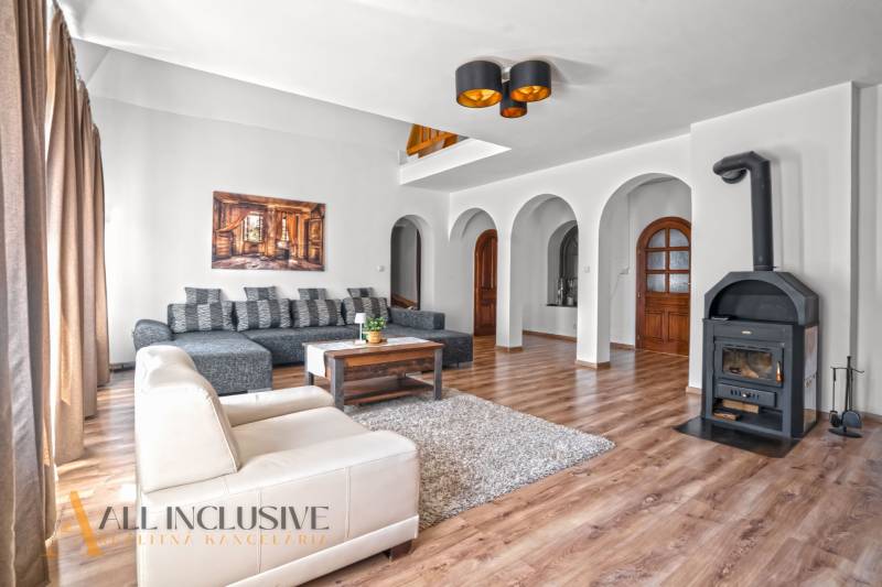 REZERVOVANÉ ZREKONŠTR. 6 IZBOVÝ RODINNÝ DOM, KOŠÚTY - Obývačka v rodinnom dome s krbom, oblúkmi a podlahou s dreveným dekorom.