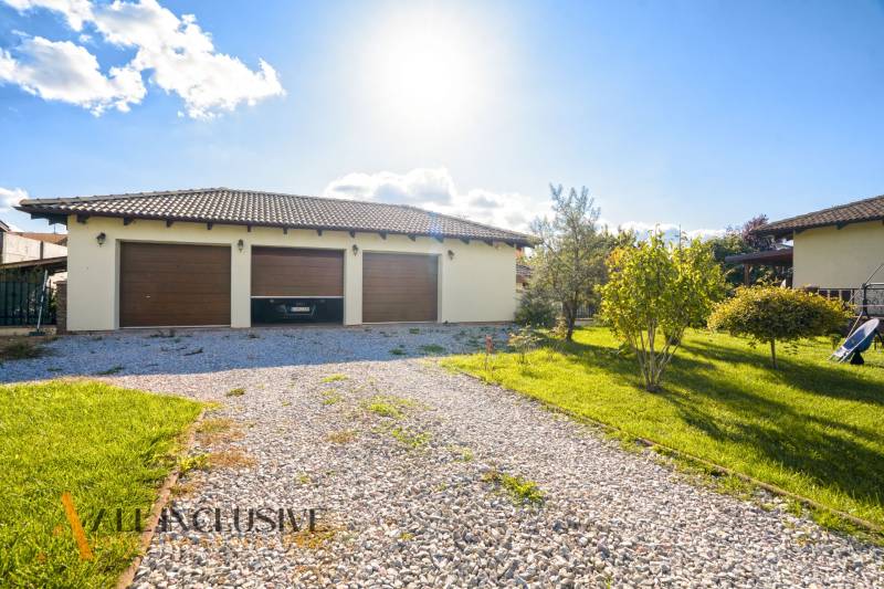 NA PREDAJ 4-IZB NOVOSTAVBA S TROJGARÁŽOU, PIN. KRAČANY - Rodinný dom na Pinkových Kračanoch, Dunajská Streda, s tromi garážovými bránami a štrkovou cestou.