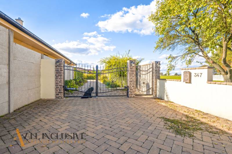 NA PREDAJ 4-IZB NOVOSTAVBA S TROJGARÁŽOU, PIN. KRAČANY - Brána rodinného domu na ulici Pinkové Kračany v Dunajskej Strede s kockovaným dláždením.