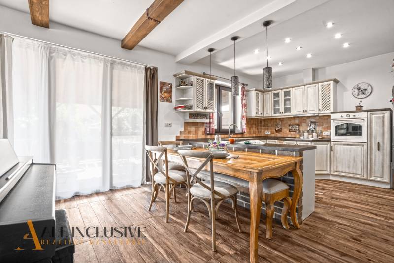 NA PREDAJ 4-IZB NOVOSTAVBA S TROJGARÁŽOU, PIN. KRAČANY - Kuchyňa rodinného domu s podlahou s dreveným dekorom a dreveným stolom.