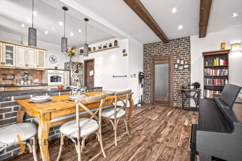 NA PREDAJ 4-IZB NOVOSTAVBA S TROJGARÁŽOU, PIN. KRAČANY - Jedáleň v rodinnom dome s podlahou s dreveným dekorom a tehlovou stenou.