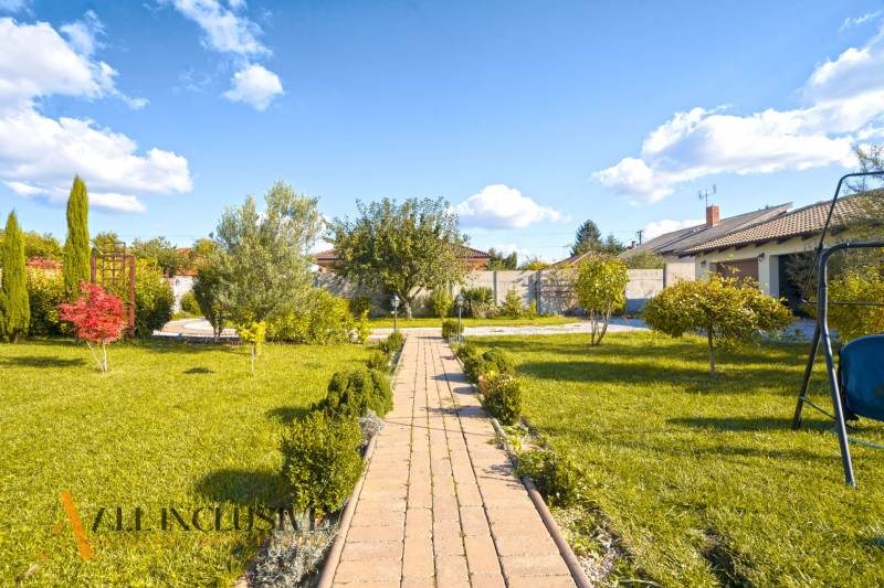 NA PREDAJ 4-IZB NOVOSTAVBA S TROJGARÁŽOU, PIN. KRAČANY - Záhrada rodinného domu na Pinkových Kračanoch v Dunajskej Strede s trávnikom a chodníkom.