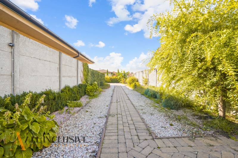 NA PREDAJ 4-IZB NOVOSTAVBA S TROJGARÁŽOU, PIN. KRAČANY - Cestička v záhrade rodinného domu v Pinkových Kračanoch, Dunajská Streda, lemovaná zeleňou.