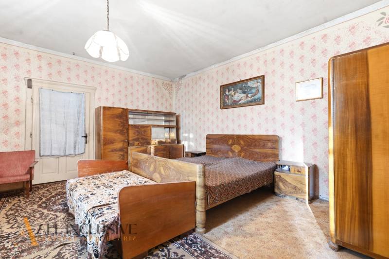 Na predaj 4-izbový rodinný dom, Dolné Saliby - Spálňa v rodinnom dome s vintage nábytkom a tapetami s kvetinovým vzorom.