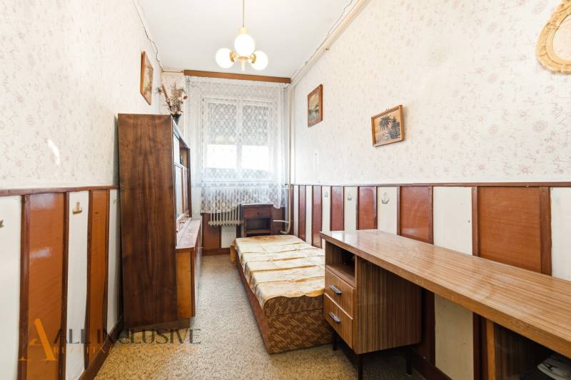 Na predaj 4-izbový rodinný dom, Dolné Saliby - Izba v rodinnom dome s dreveným nábytkom a kobercom, jemne zdobené steny.