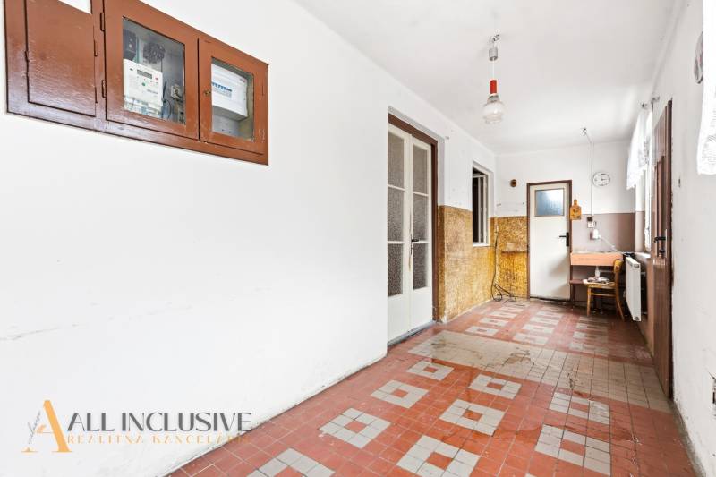 Na predaj 3-izbový rodinný dom, Dobrohošť - Chodba v rodinnom dome s dlažbou, dverami a elektrickým rozvádzačom na stene.