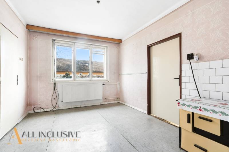 Na predaj 3-izbový rodinný dom, Dobrohošť - Interiér rodinného domu so vzorovanými stenami, oknom a kuchynskou linkou.