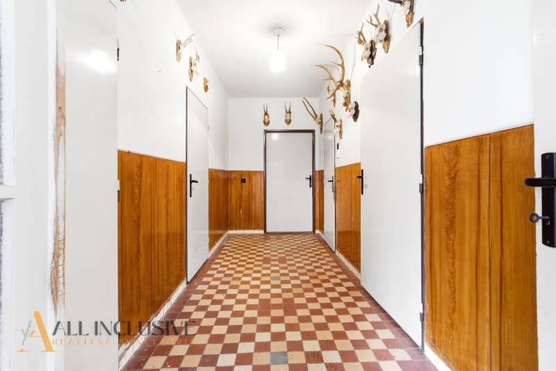 Na predaj 3-izbový rodinný dom, Dobrohošť - Chodba v rodinnom dome s poľovníckymi trofejami a dlaždicovou podlahou.