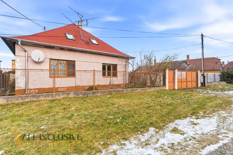 Na predaj 3-izbový rodinný dom, Dobrohošť - Rodinný dom v Dobrohošti s červenou strechou a oploteným pozemkom. Trávnatá plocha so snehom.