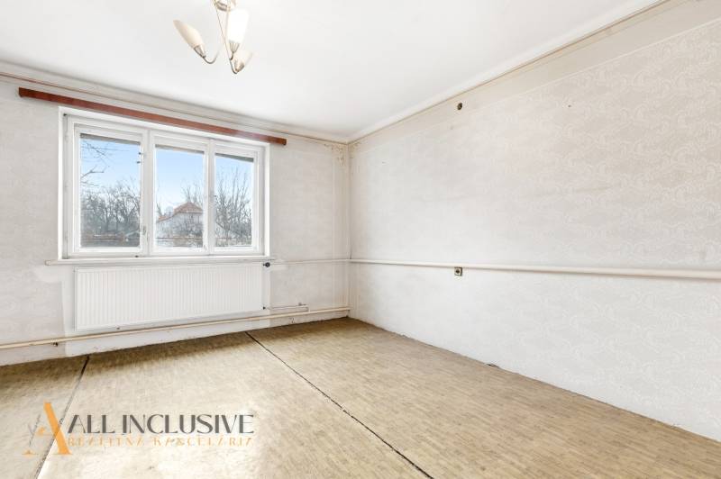 Na predaj 3-izbový rodinný dom, Dobrohošť - Svetlá izba s podlahou s dreveným dekorom, veľkým oknom a radiátorom, rodinný dom.