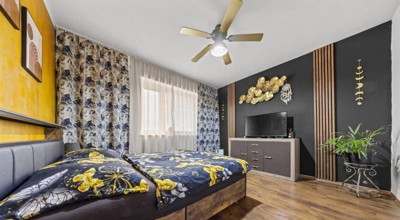 Na predaj 5-izb. rodinný dom na 50-á pozemku, Sap - Spálňa v rodinnom dome s farebnou posteľou, dreveným dekorom a výraznou nástennou výzdobou.