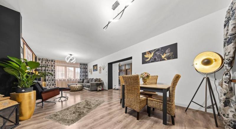 Na predaj 5-izb. rodinný dom na 50-á pozemku, Sap - Rodinný dom s podlahou s dreveným dekorom, ratanovým nábytkom a osvetlením v obývačke.