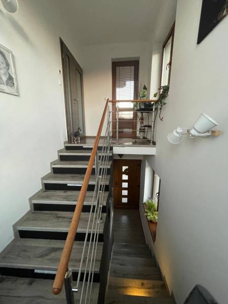 Na predaj 5-izb. rodinný dom na 50-á pozemku, Sap - Schodisko v rodinnom dome s dekoráciami, kresbou na stene a dreveným zábradlím.