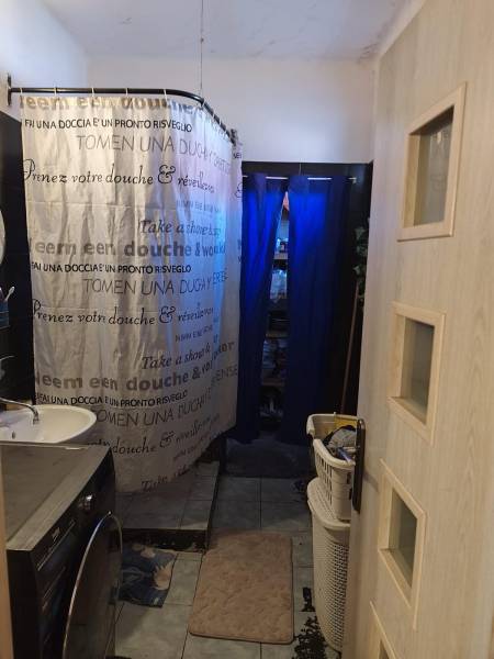 Na predaj 3-izb. rodinný dom, Gabčíkovo – Polná ulica - Kúpeľňový kút so sprchovým závesom a práčkou v rodinnom dome na Poľnej v Gabčíkove.