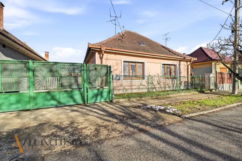 Na predaj 3-izb.rod.dom s dvojgarážou,Vojka nad Dunajom - Rodinný dom vo Vojke nad Dunajom so zelenou bránou a murovaným plotom.