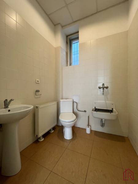 Reprezentatívne priestory na prenájom, Mlynská, Košice - Staré mesto - Kúpeľňa v kanceláriách so záchodom, umývadlom a radiátorom na svetlej dlažbe.
