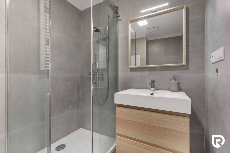| Krásny a moderný 2-izbový byt | 51,50m² | - Kúpeľňa s preskleným sprchovým kútom a umývadlom v 2-izbovom byte.