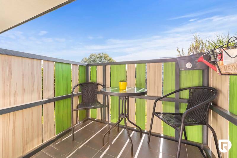 | Krásny a moderný 2-izbový byt | 51,50m² | - Balkón v 2-izbovom byte s ratanovými stoličkami a stolíkom, zelené drevené zábradlie.