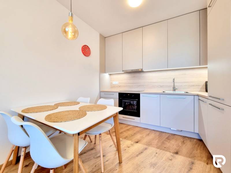 Posledný investičný krásny 2-izbový byt | 55 m² | RÍNOK RAČA - Kuchyňa v 2-izbovom byte s jedálenským stolom, podlaha s dreveným dekorom.