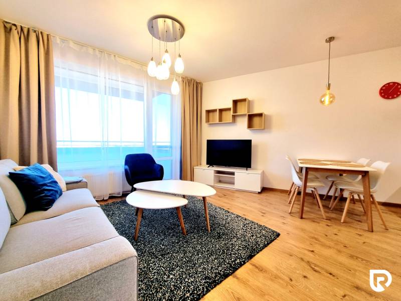 Posledný investičný krásny 2-izbový byt | 55 m² | RÍNOK RAČA - Obývacia izba s pohovkou, televízorom a jedálenským stolom, podlaha s dreveným dekorom.