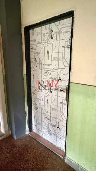 Predaj garsónky – Tlmače, Lipník- ihneď voľná (MK-3) - Dvere pokryté mestským motívom, podlaha s dreveným dekorom, stena v sýtozelenej farbe.