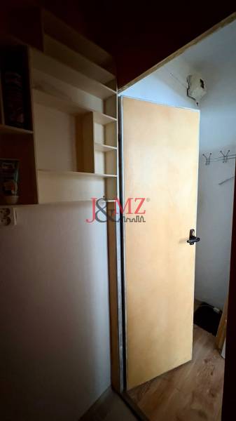 Predaj garsónky – Tlmače, Lipník- ihneď voľná (MK-3) - Otvorené dvere, stena s policami, háčiky. Garsónka s podlahou s dreveným dekorom.