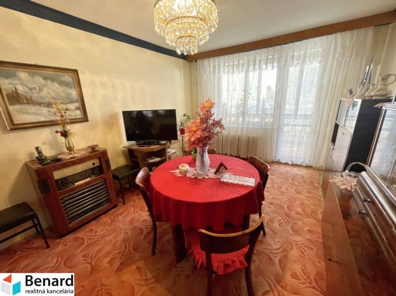 PREŠOV-3 IZBOVÝ BYT,LODŽIA,67m2,SÍDLISKO III.,MATICE SLOVENSKEJ - Jedálenská časť v 3-izbovom byte s červeným obrusom a veľkými oknami.