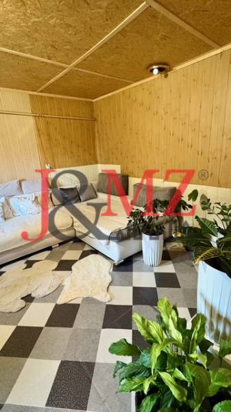Útulný rodinný dom v tichej lokalite Mýtnych Ludán (MK-4) - Interiér rodinného domu s rohovou sedačkou, rastlinami a vzorovanou podlahou s dreveným dekorom.