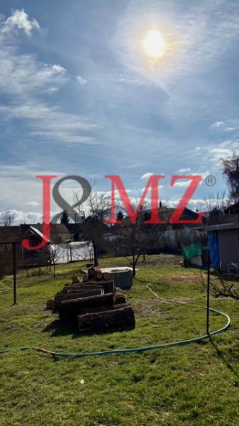 Útulný rodinný dom v tichej lokalite Mýtnych Ludán (MK-4) - Záhrada s pokoseným trávnikom a drevom v areáli rodinného domu v Mýtnych Ludanoch.