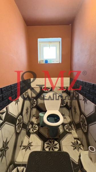 Útulný rodinný dom v tichej lokalite Mýtnych Ludán (MK-4) - Kúpeľňa v rodinnom dome s výrazným geometrickým obkladom a oranžovými stenami.