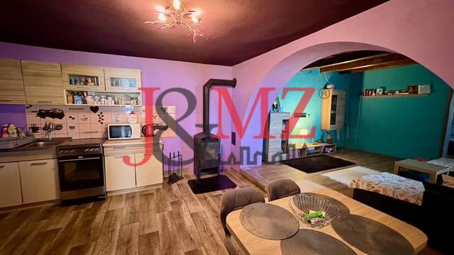 Útulný rodinný dom v tichej lokalite Mýtnych Ludán (MK-4) - Kuchyňa a obývačka v rodinnom dome s podlahou s dreveným dekorom a krbom.