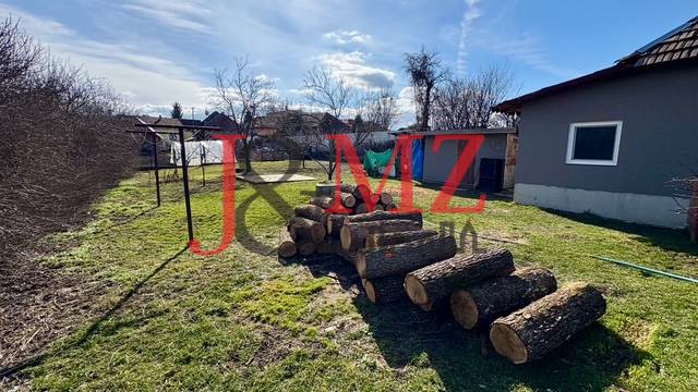 Útulný rodinný dom v tichej lokalite Mýtnych Ludán (MK-4) - Dvor rodinného domu v Mýtnych Ludanoch so stohom dreva a oplotením.