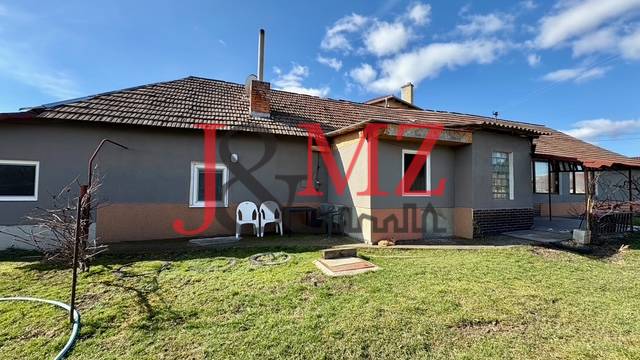 Útulný rodinný dom v tichej lokalite Mýtnych Ludán (MK-4) - Rodinný dom v Mýtnych Ludanoch s priestrannou záhradou pod jasným modrým nebom.