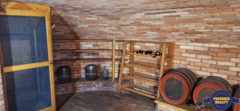 Luxusný rodinný dom s bazénom a dvojgarážou v Komárne - Vínna pivnica s tehlovými stenami a sudmi v rodinnom dome.