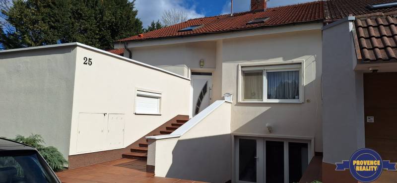 Luxusný rodinný dom s bazénom a dvojgarážou v Komárne - Rodinný dom v Komárne s bielou fasádou a červenou strechou.