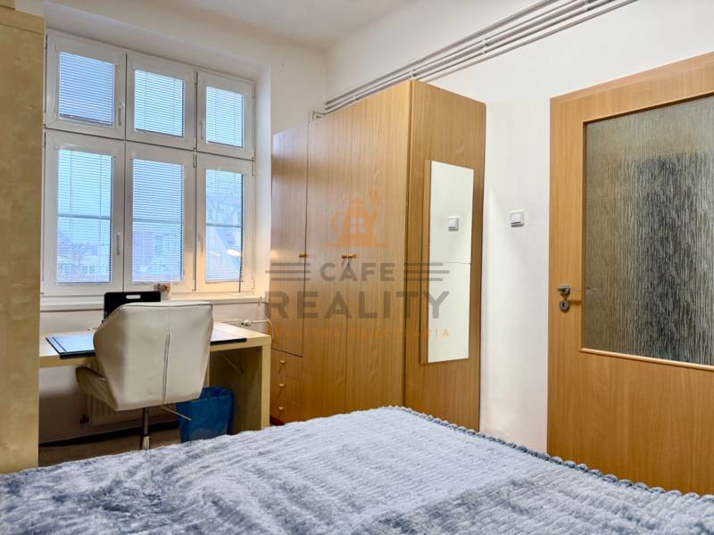 REZERVOVANÉ Na prenájom 3 izbový byt, 73 m2, Bratislava, Zochova - Spálňa v 3-izbovom byte so stolom, bielym kreslom a skriňou.