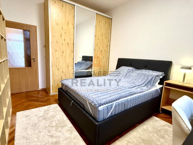 REZERVOVANÉ Na prenájom 3 izbový byt, 73 m2, Bratislava, Zochova - Spálňa v 3-izbovom byte s posteľou, šatníkom a podlahou s dreveným dekorom.