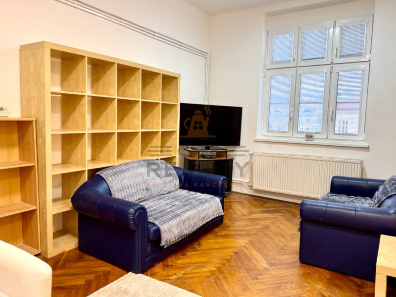 REZERVOVANÉ Na prenájom 3 izbový byt, 73 m2, Bratislava, Zochova - Obývačka v 3-izbovom byte s pohovkami, TV a podlahou s dreveným dekorom.