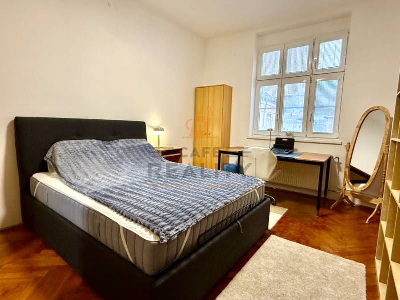 REZERVOVANÉ Na prenájom 3 izbový byt, 73 m2, Bratislava, Zochova - Spálňa s posteľou, písacím stolom a podlahou s dreveným dekorom v 3-izbovom byte.