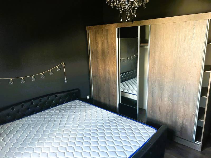 Zariadený 3 izbový byt s balkónom v Kittsee  - Spálňa s čiernymi stenami, posteľou, zrkadlom a skriňou v 3-izbovom byte.